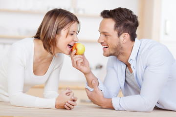 lachendes junges paar mit einem apfel