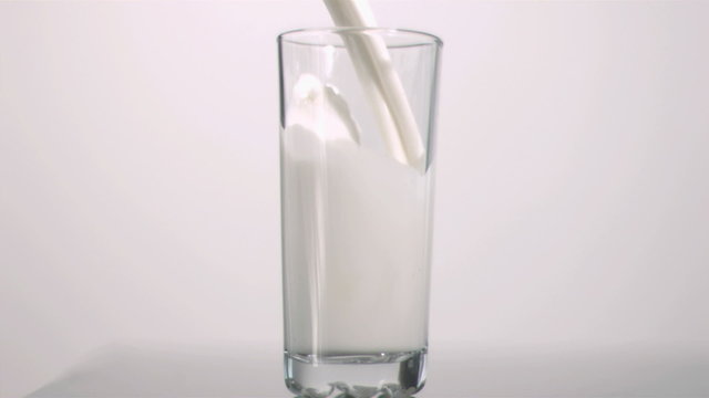 Milk filling a glass in super slow motion