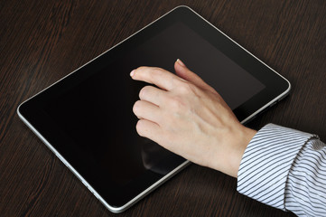 Female hand touching screen of tablet pc