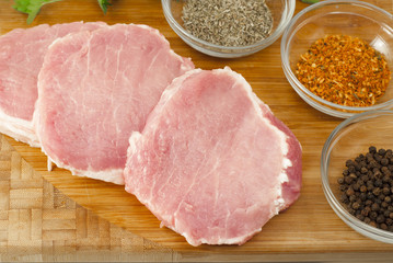 Pork chops on a cutting board with herbs