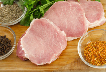 Pork chops on a cutting board with herbs