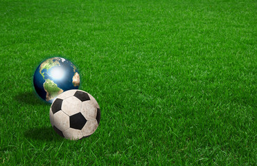 soccer ball and earth on green grass