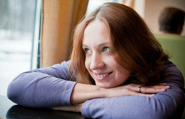 Pretty young woman leaning on a table