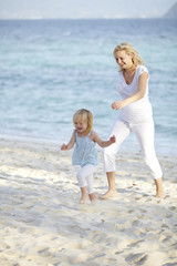 Naklejka premium junge schwangere mutter mit ihrer tochter am strand