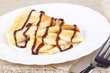 Thin pancakes with banana and chocolate