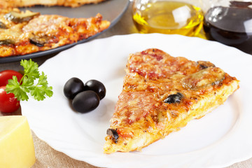 Italian cuisine. Pizza with salami, pickles and olives