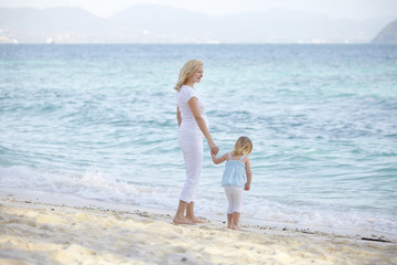 junge schwangere mutter mit ihrer tochter am strand