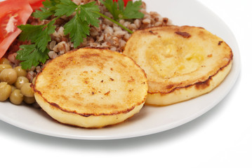 Fried vegetable marrows and buckwheat cereal with tomatoes