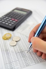 Calculator, coins and pen on a business background