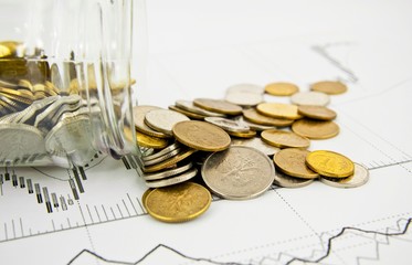 Coins Spilled From Jar on business background.