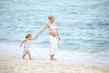 junge schwangere mutter mit ihrer tochter am strand