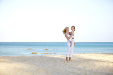 Fototapeta na wymiar junge schwangere mutter mit ihrer tochter am strand
