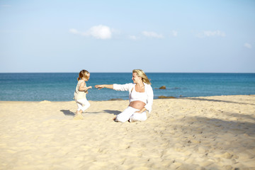 junge schwangere mutter mit ihrer tochter am strand