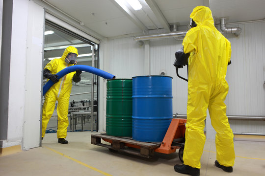 Two professionals working with  toxic waste in factory