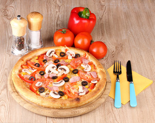 Aromatic pizza with vegetables on wooden background