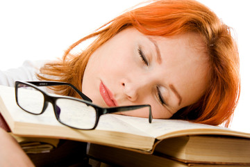 Beautiful red-haired girl in glasses reads book.