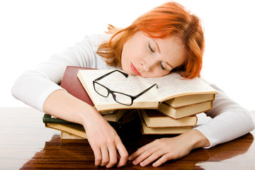 Beautiful red-haired girl in glasses reads book.