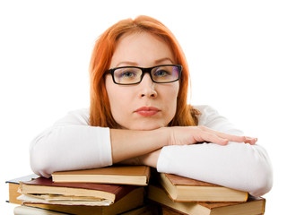 Beautiful red-haired girl in glasses reads book.