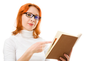 Beautiful red-haired girl in glasses reads book.