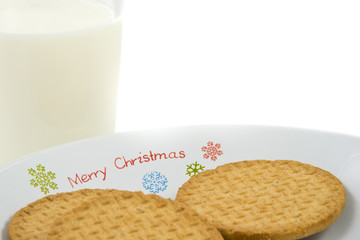 Crumbly cookies on dish with glass of milk