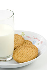 Crumbly cookies on dish with glass of milk