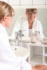 woman smiling through looking glass in her bathroom