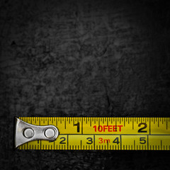 Measuring tape on a black metallic background