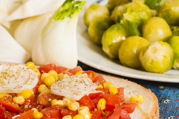 bruschetta with tomato, onion and corn on blue tablecloth
