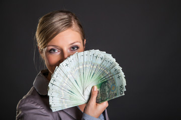 Woman with polish zloty money on dark gray background