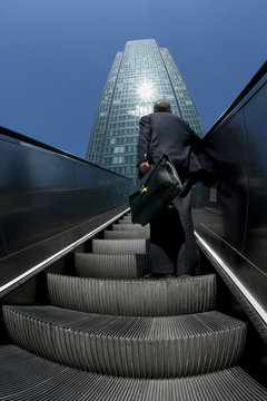 Man Approaching Business Building With Escalator