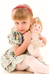 Portrait of happy little girl with a doll