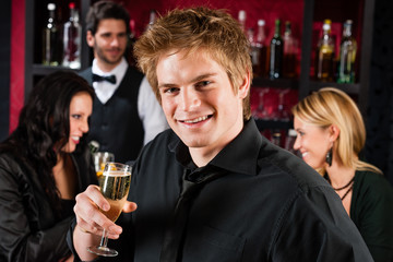 Young man at the bar drink champagne