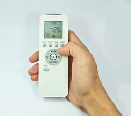 Hand is holding a remote control of air conditioner isolated