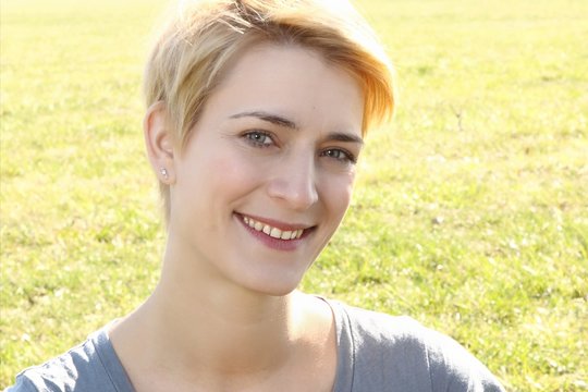 Portrait lachende Frau im Gr&uuml;nen