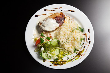 Cutlet with rice and vegetables on a white plate