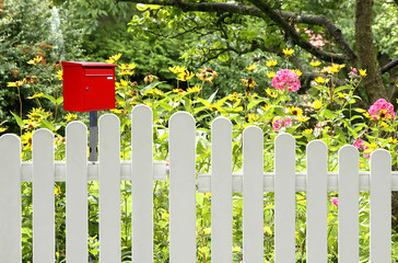 Roter Briefkasten am Gartenzaun
