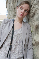 Jeune femme posant la tête contre un mur