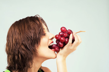 Beautiful woman eating grapes