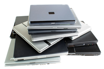 Stack of used laptop computers, isolated on white