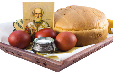 Easter eggs and kulich, salt, an icon on a wooden tray