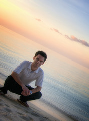Fototapeta na wymiar Atrakcyjny mężczyzna na plaży z zachodem słońca / sunrise (Malediwy)