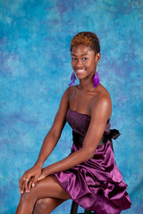 Black woman sitting looking at the camera with a smile