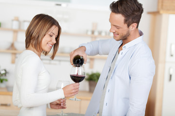 mann schenkt seiner freundin wein ein