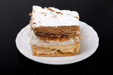 sweet  cake with cream isolated on black