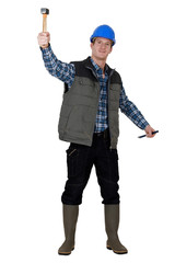 Laborer lifting hammer, studio shot