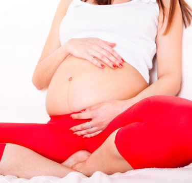 woman holding her hands on  pregnant belly