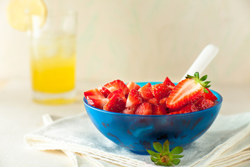 Strawberry Fruit Salad in a Blue Bowl with Lemonade