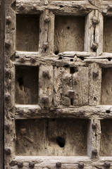 Puerta vieja de madera con clavos y cerradura, fondo, textura.