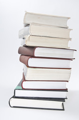 Stack of books with opened notebook and glasses