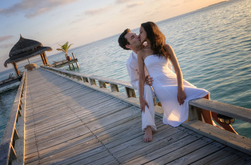 Sinnliches sexy Paar in weißer Kleidung am Pier (Malediven)